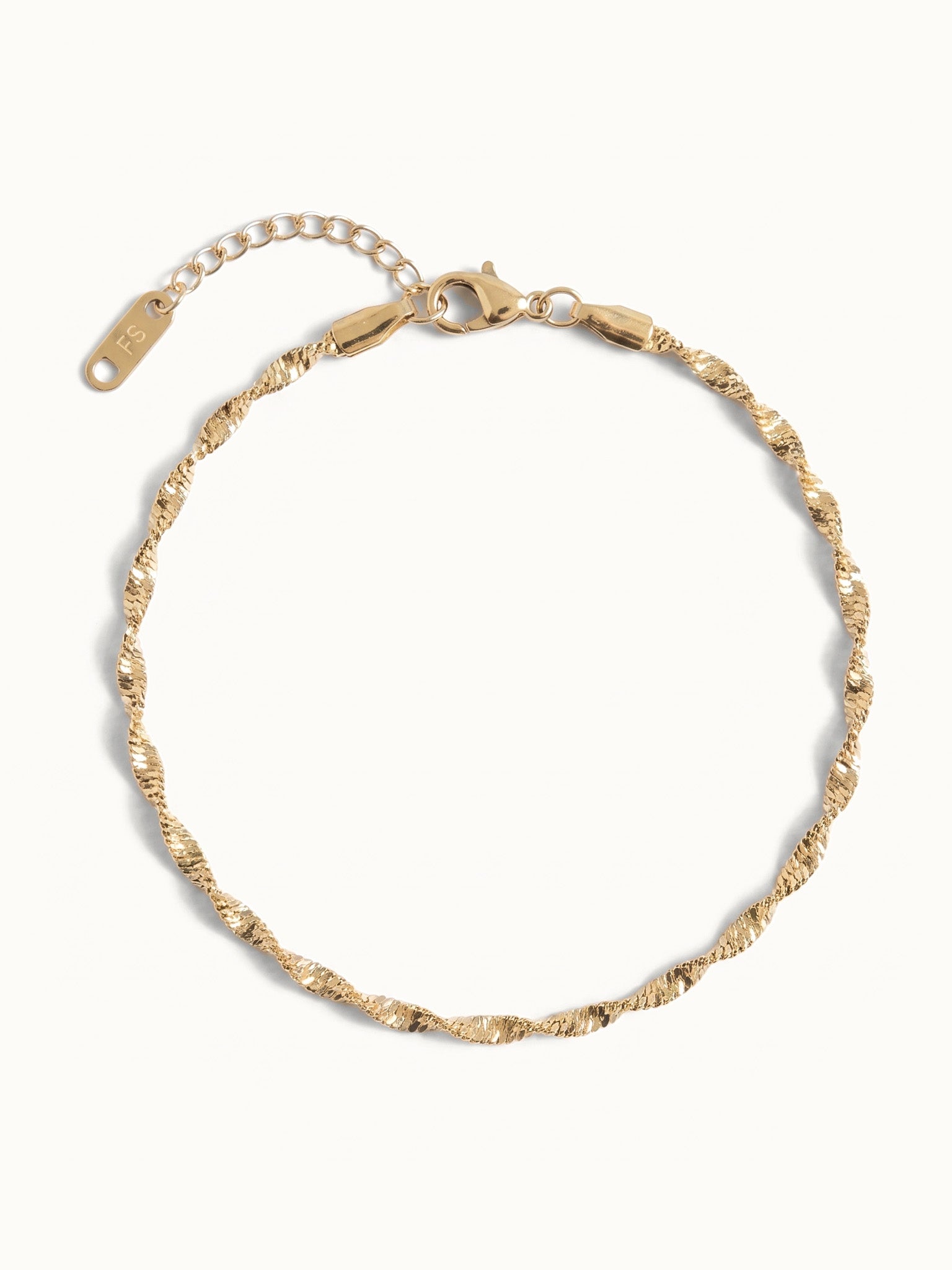 Anchor Twist Chain Bracelet – laid in a circle, seen from above, gold, on ivory background