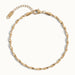 Anchor Twist Chain Bracelet – laid in a circle, seen from above, gold, on ivory background