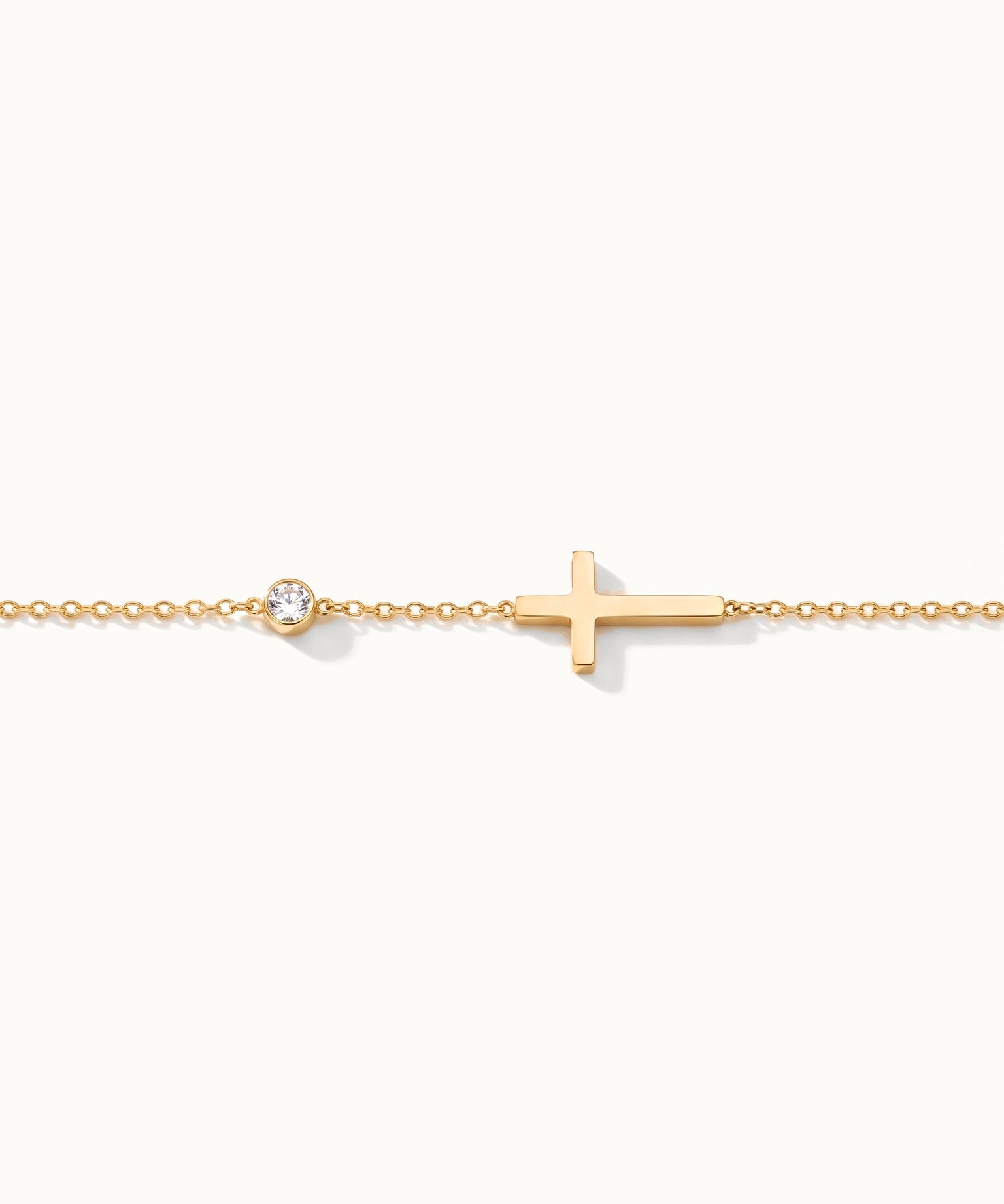 Beside Me Cross Bracelet in gold, laid straight with the cross and stone