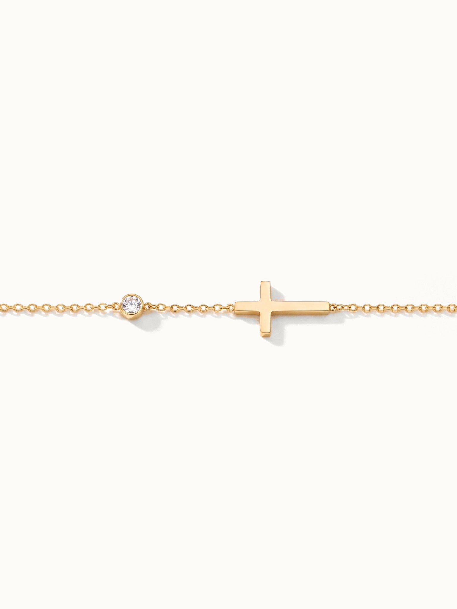 Beside Me Cross Bracelet in gold, laid straight with the cross and stone