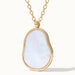 Dawn Pearl Pendant Necklace – close-up of the mother-of-pearl pendant and chain, gold, on ivory background