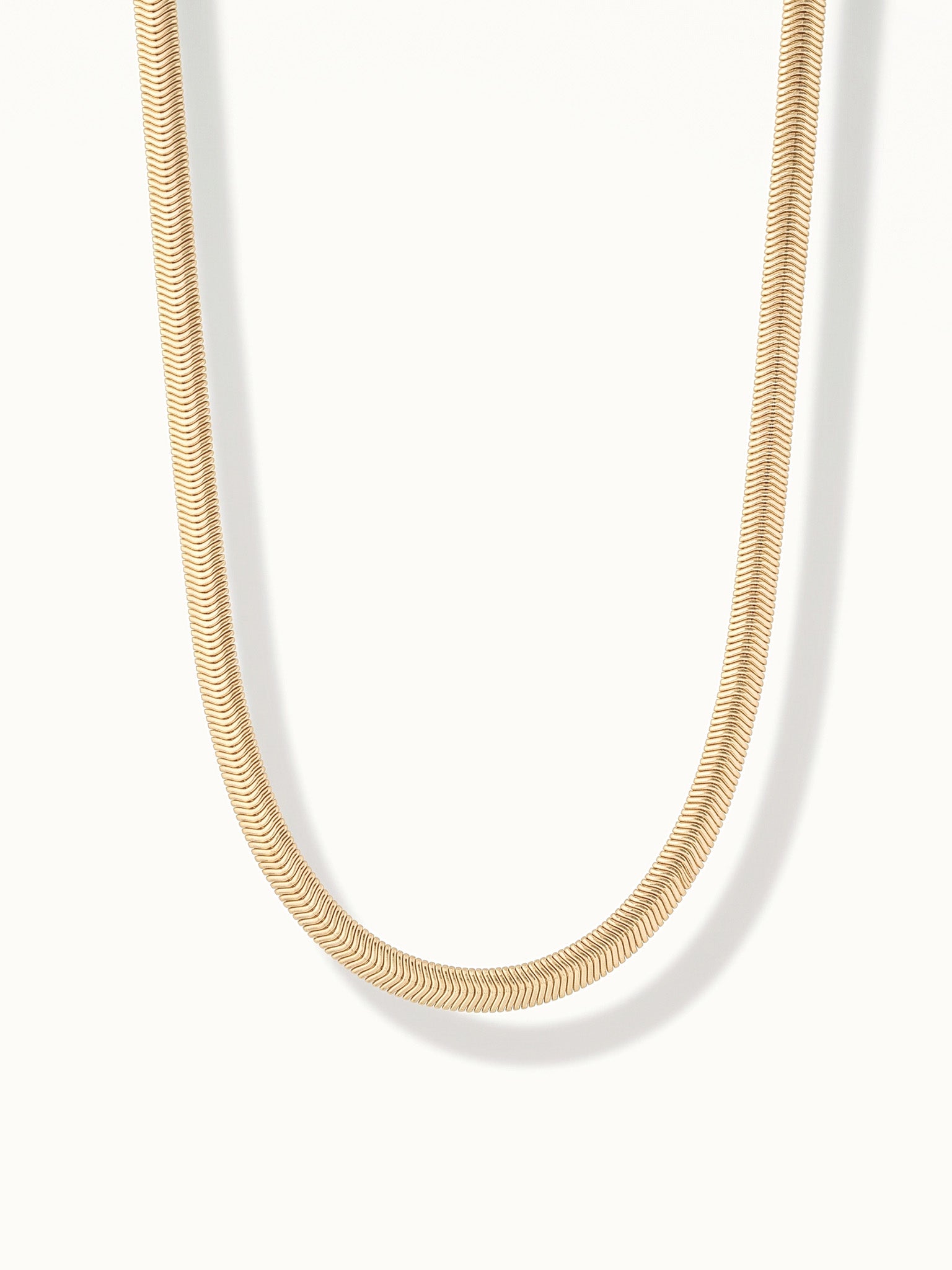 Everlasting Chain Necklace – flat snake chain hanging in a drop, gold, on ivory background