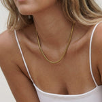 Everlasting Chain Necklace – worn at the collarbone, head turned, gold, white camisole