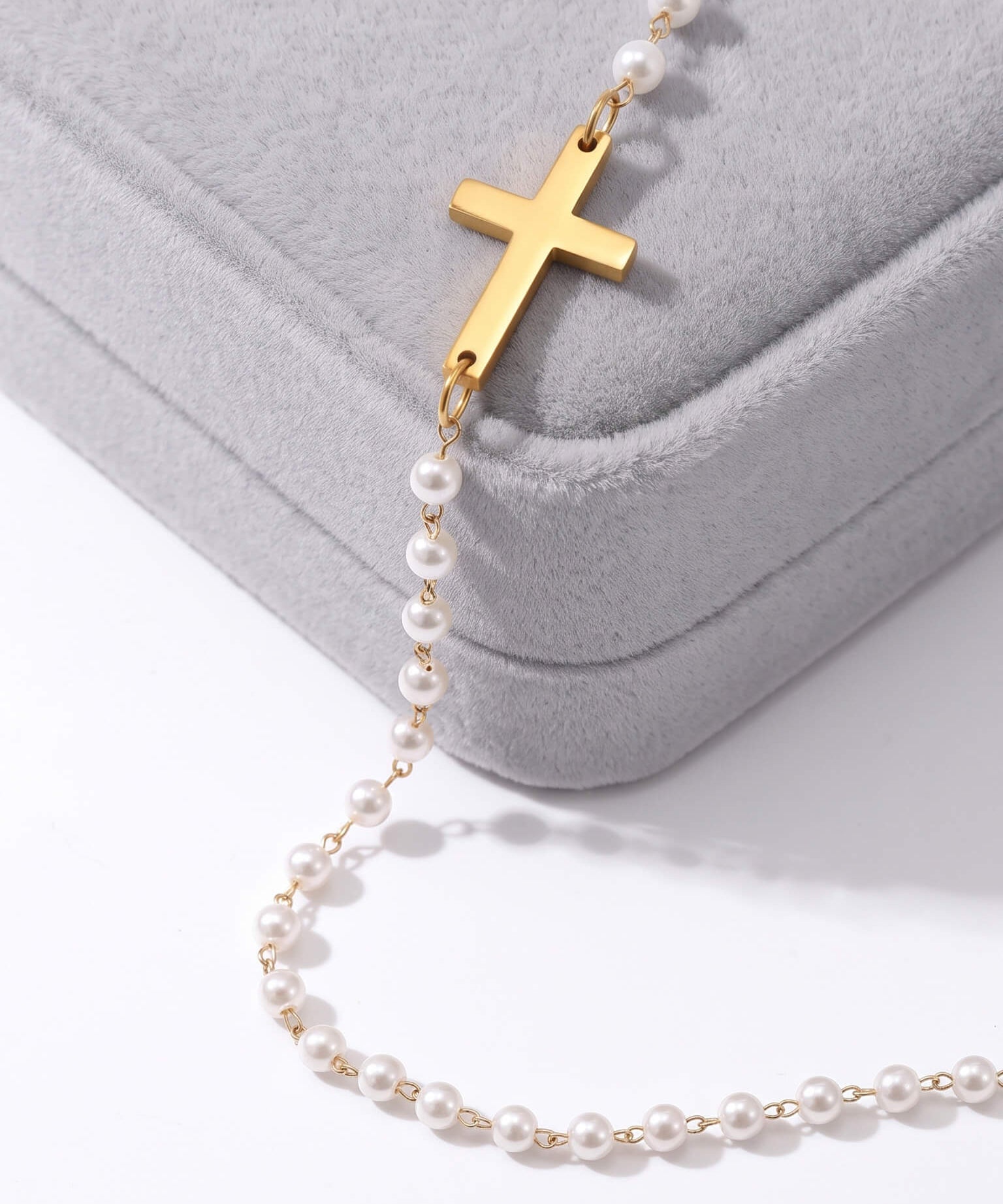 Every Season Cross Necklace – gold cross and pearls draped over a grey velvet Fallen Season box