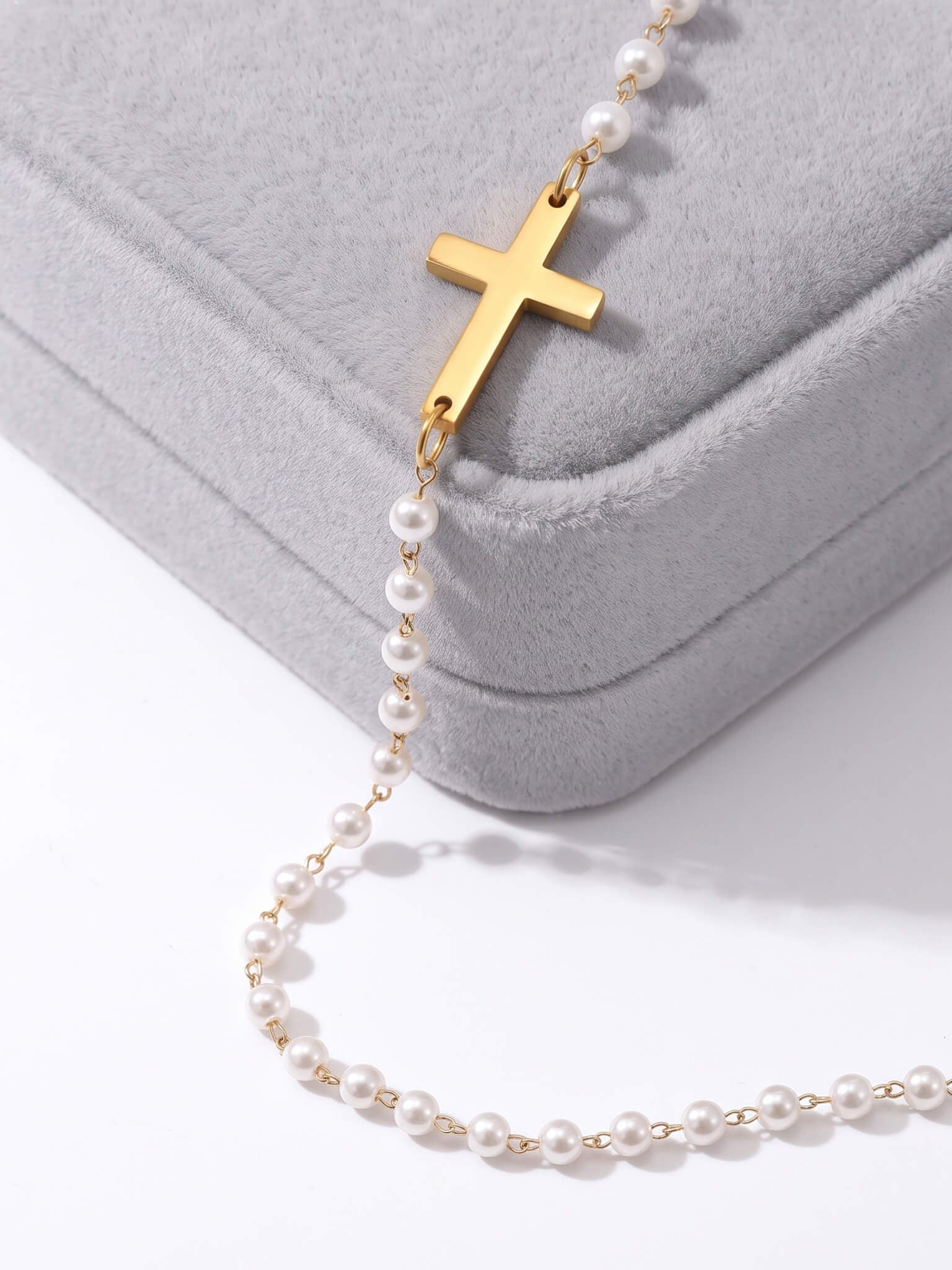 Every Season Cross Necklace – gold cross and pearls draped over a grey velvet Fallen Season box