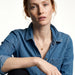 Everyday Loop Necklace – gold loop pendant on a fine chain, model seated with one arm resting on her knee, blue denim shirt, ivory studio background