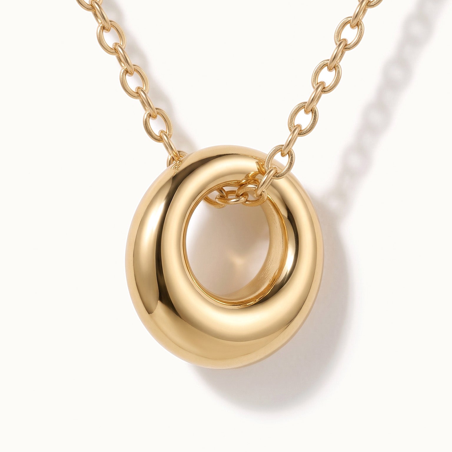 Everyday Loop Necklace – close-up of the loop pendant on its chain, gold, on ivory background