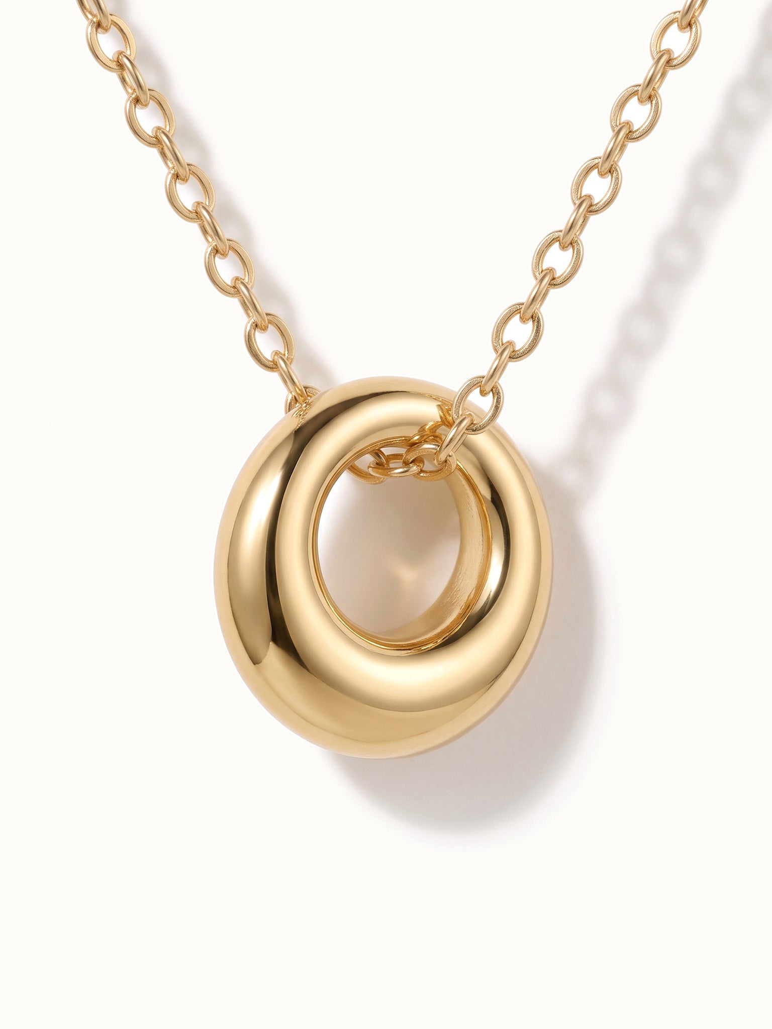 Everyday Loop Necklace – close-up of the loop pendant on its chain, gold, on ivory background
