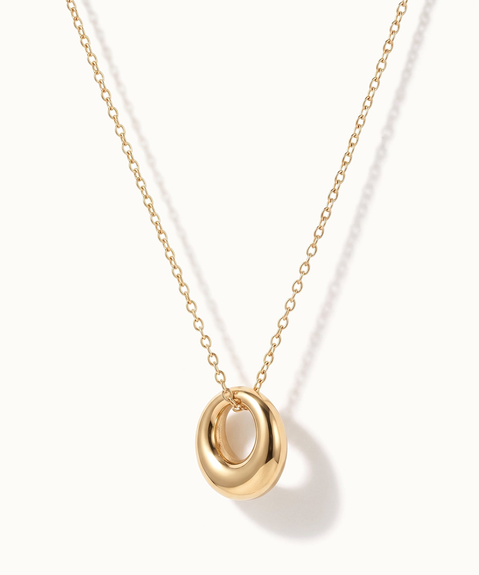 Everyday Loop Necklace – loop pendant hanging on a fine chain, turned to the side, gold, on ivory background