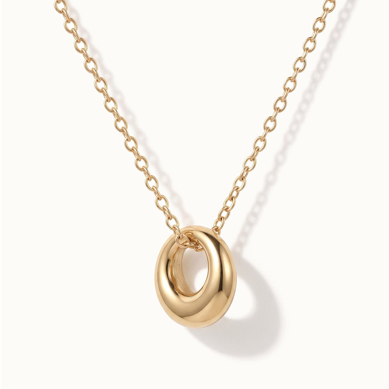 Everyday Loop Necklace – loop pendant hanging on a fine chain, gold, on ivory background