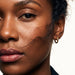 Faithful Hoops – worn in the ear, close crop of the face with loose hair across the cheek, gold hoop, curly hair up