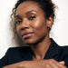 Faithful Hoops – worn in the ear, leaning against a wall with arms folded, gold hoop, curly hair up
