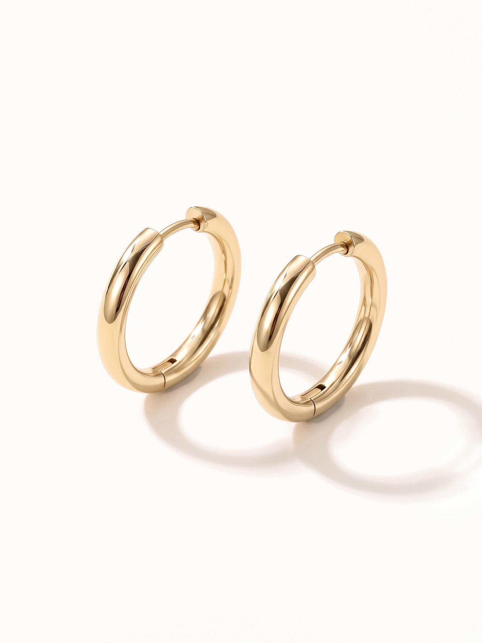 Faithful Hoops – pair of plain polished hoops, angled view, gold, on ivory background