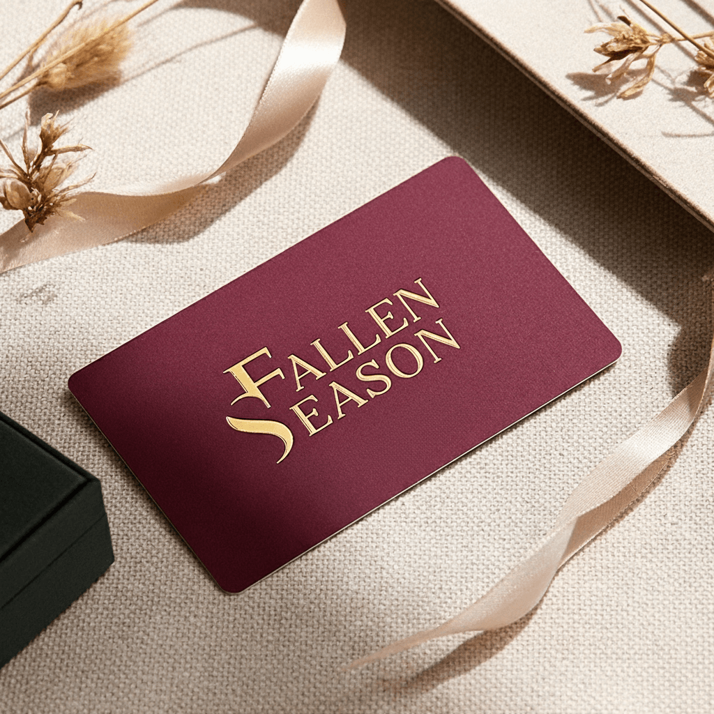 Fallen Season gift card in burgundy and gold foil, styled with dried flowers and ribbon