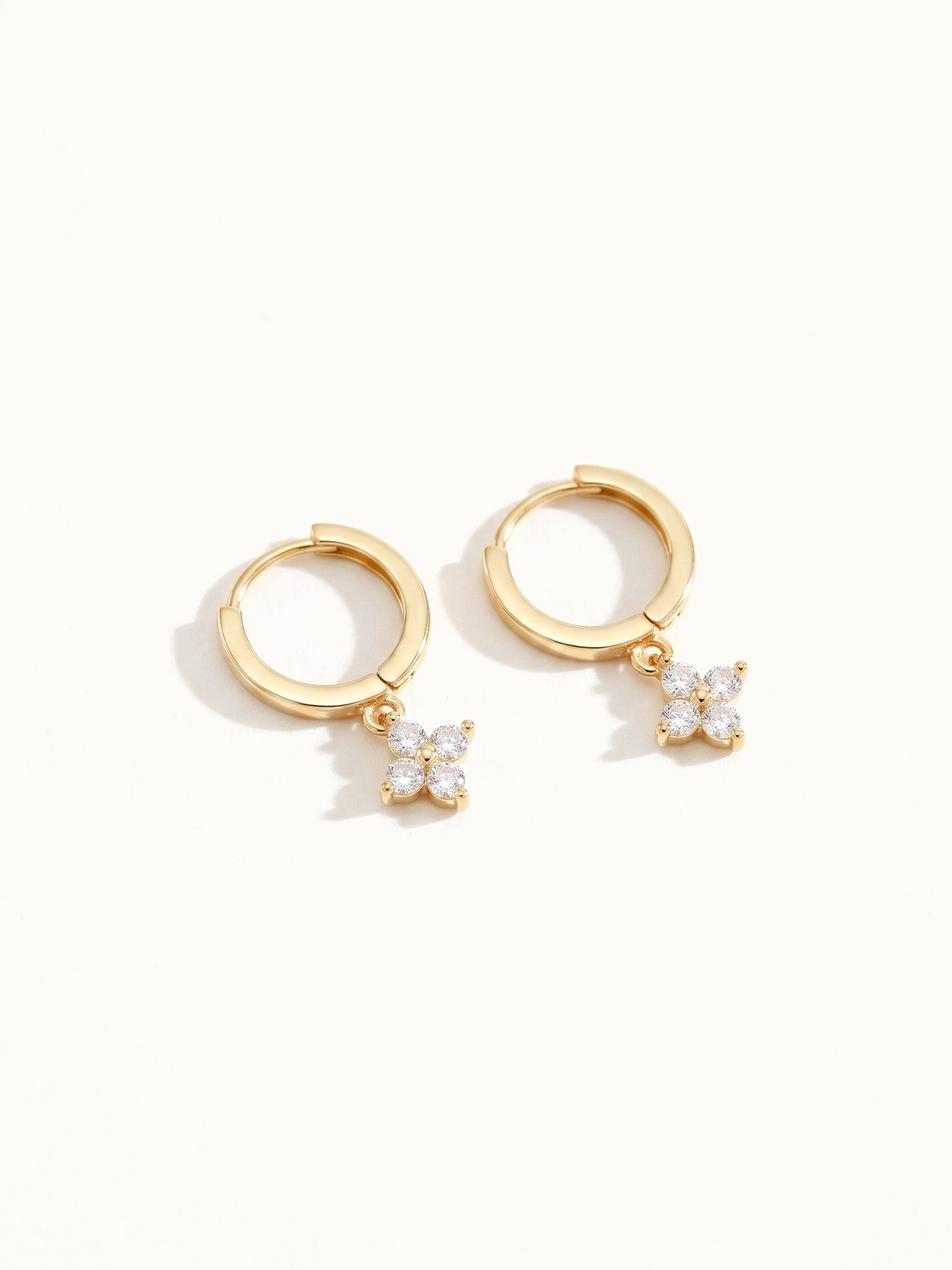 Field Lily Drop Earrings – pair of flower drop huggie hoops, lying flat, gold, on ivory background