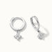 Field Lily Drop Earrings – pair of flower drop huggie hoops, close-up, silver, on ivory background