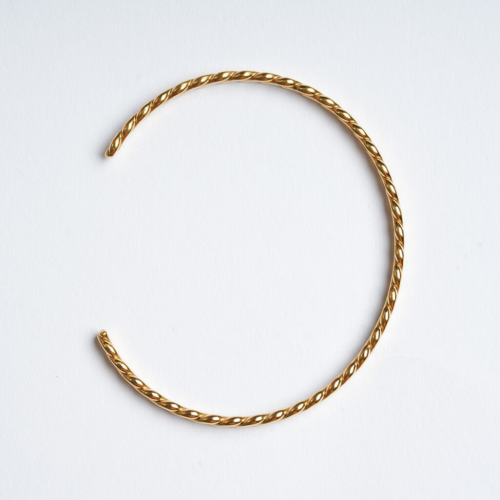 Fire & Roots Cuff – open cuff seen from above, gold, on a pale grey background