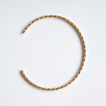 Fire & Roots Cuff – open cuff seen from above, gold, on a pale grey background