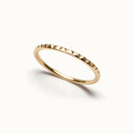 Fire Band – faceted band, angled view, gold, on ivory background