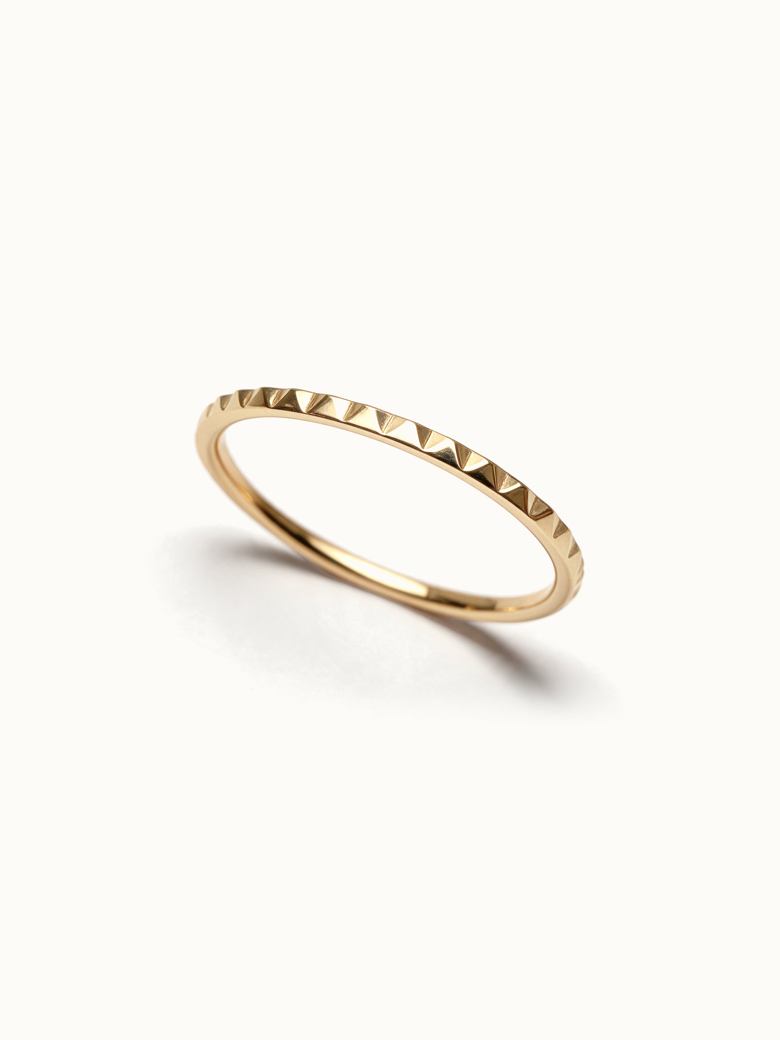 Fire Band – faceted band, angled view, gold, on ivory background
