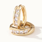 Four Seasons Huggies – close-up of the four-stone huggie hoops, gold, on ivory background