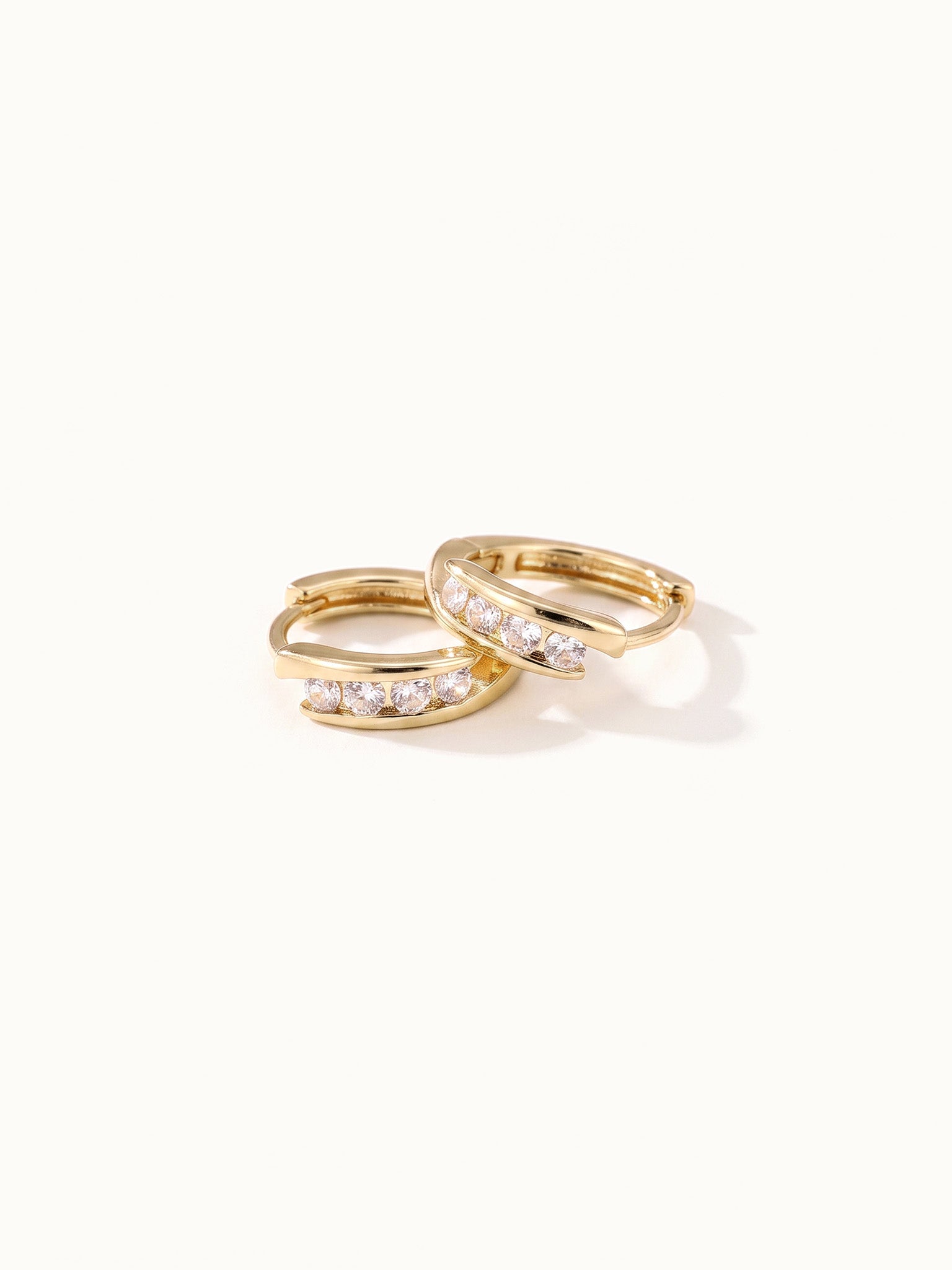 Four Seasons Huggies – pair of four-stone huggie hoops, gold, on ivory background