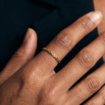 Golden Season Band – worn on the hand, close-up of the woven texture, gold, dark top