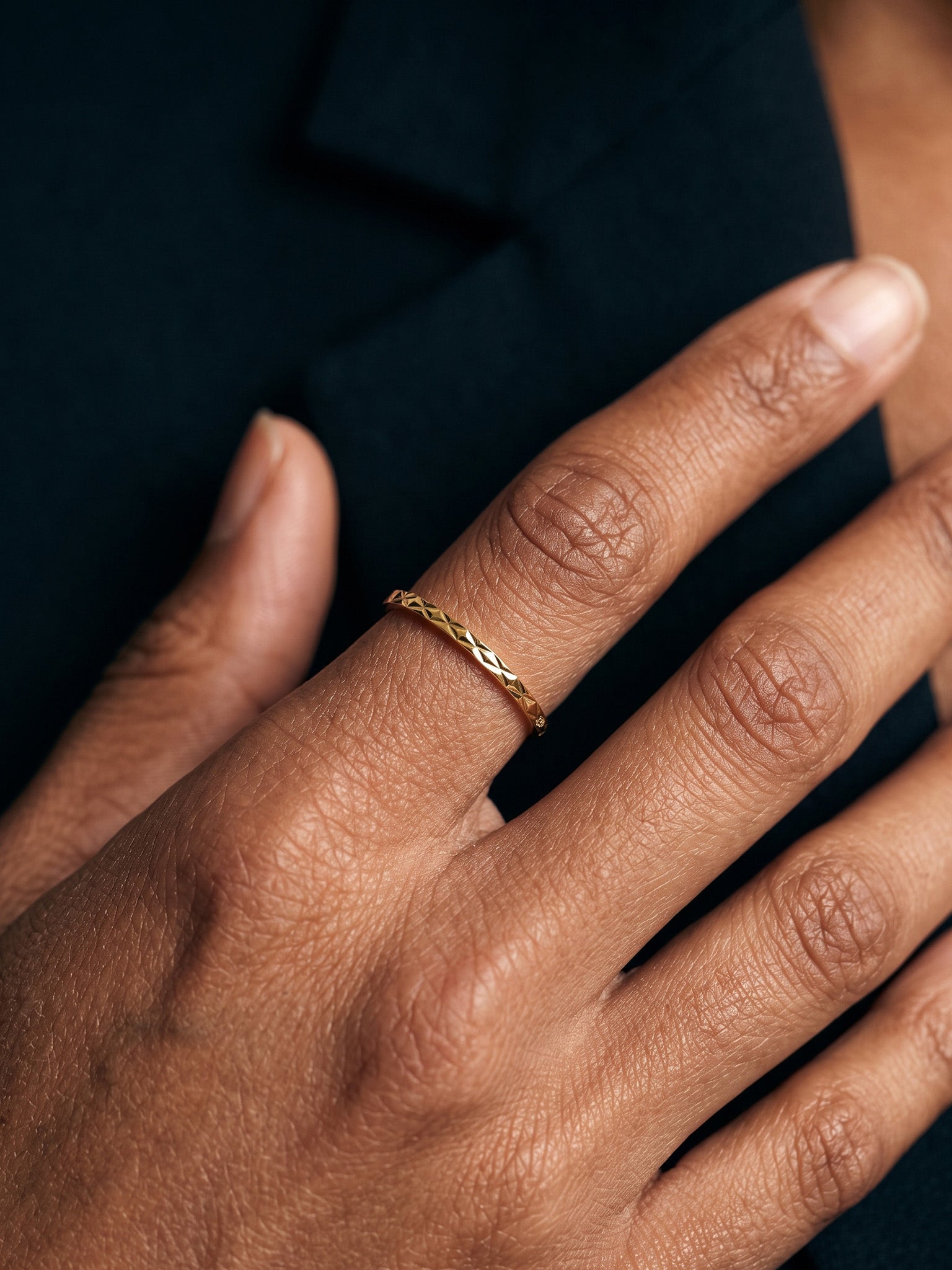 Golden Season Band – worn on the hand, close-up of the woven texture, gold, dark top