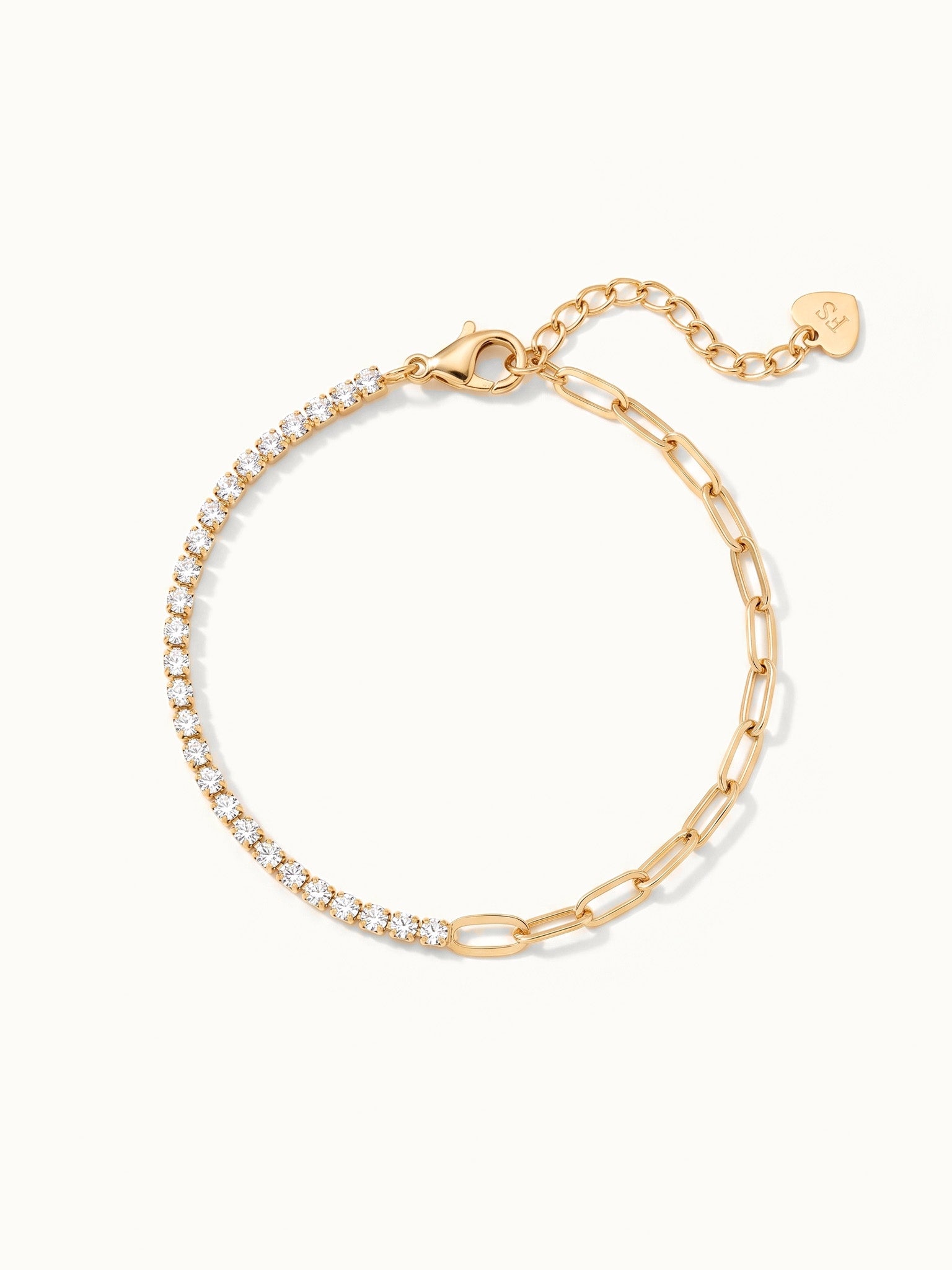 Grace Line Bracelet – laid in a circle with clasp and extender at the top, seen from above, gold, on ivory background