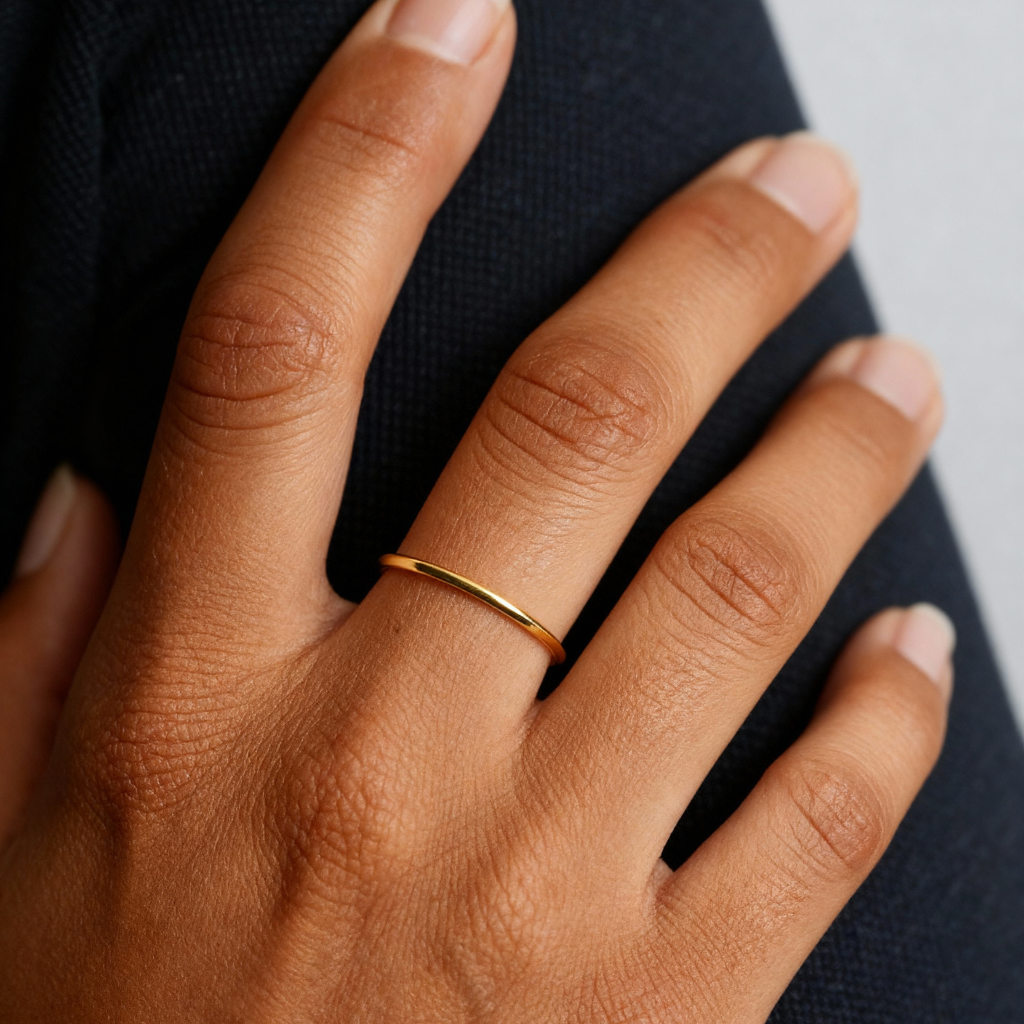 Grace Stack Ring in gold worn on a woman's hand resting on dark fabric