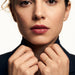 Halo Band Ring – worn with both hands holding the blazer collar, gold, dark blazer, ivory studio background