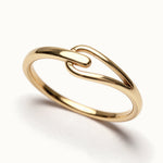 Held Ring – close-up of the soft link, gold, on ivory background
