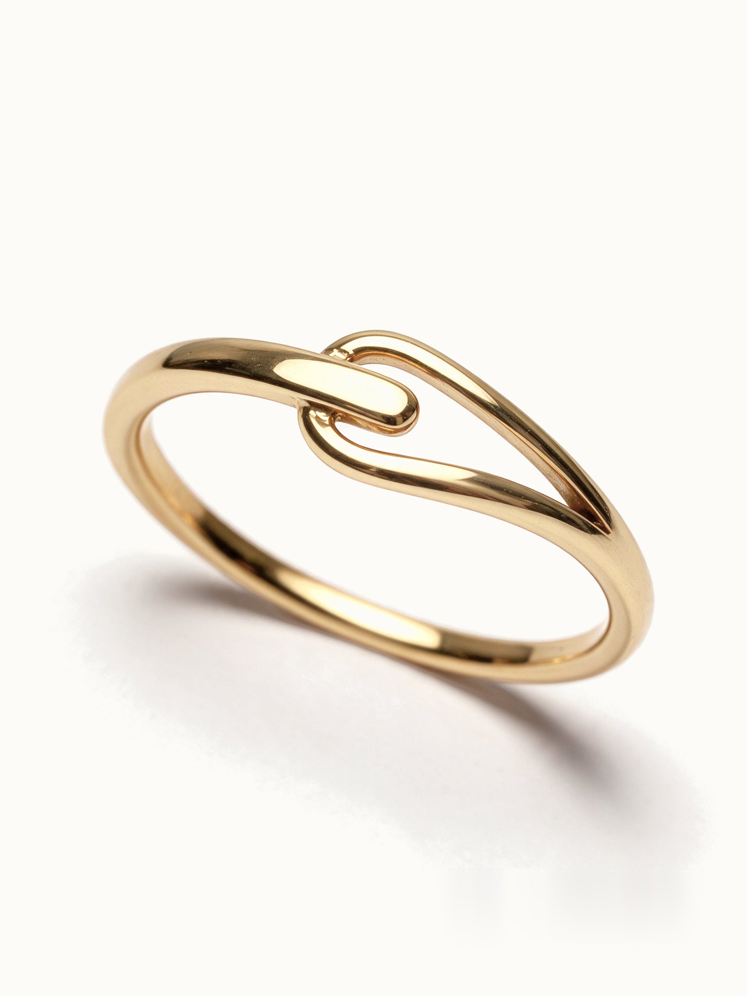 Held Ring – close-up of the soft link, gold, on ivory background