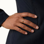 Held Ring – worn with the hand resting on the hip, gold, dark blazer, ivory studio background