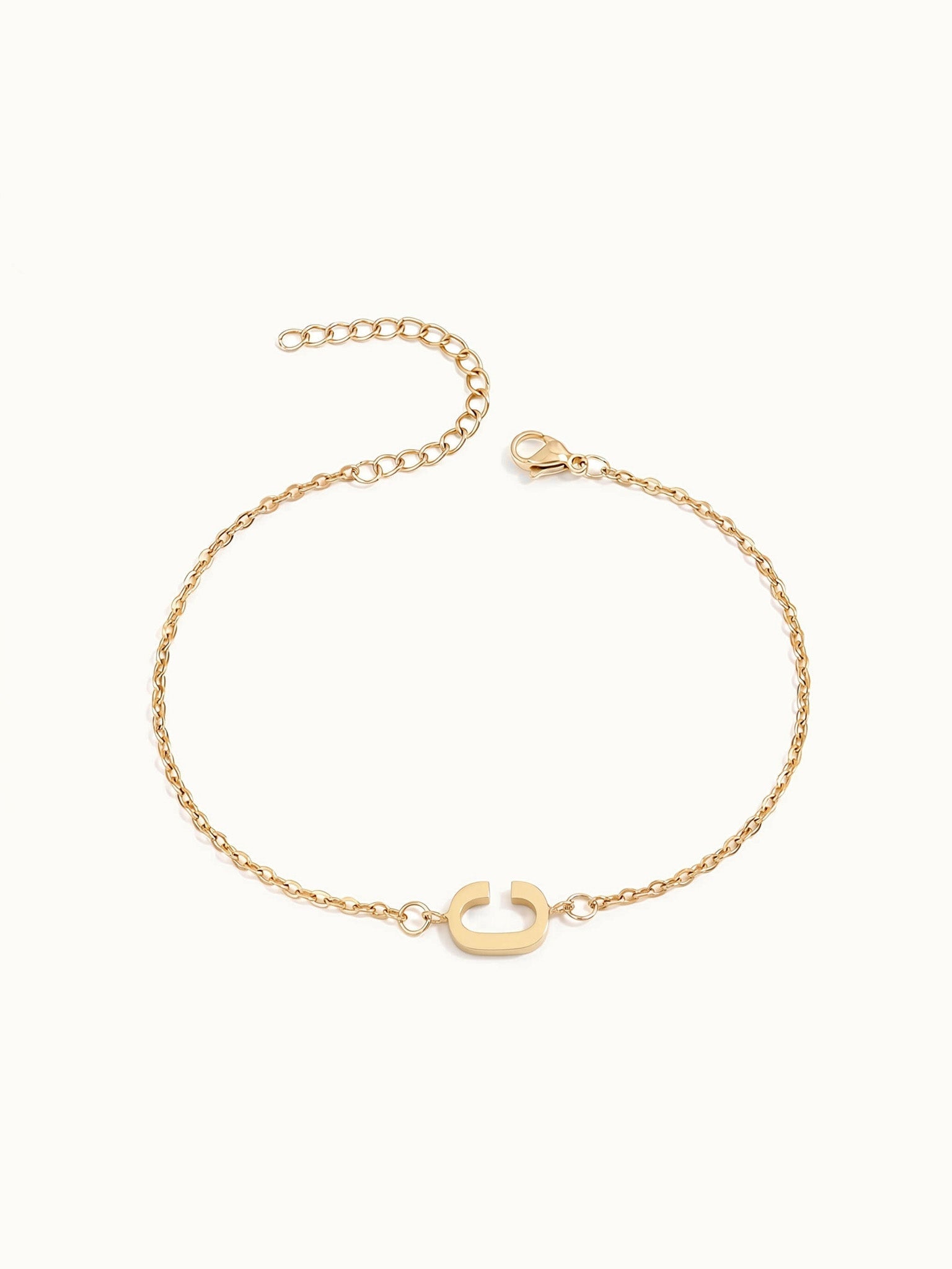 Initial Bracelet – letter C charm on a fine cable chain, gold, on ivory background