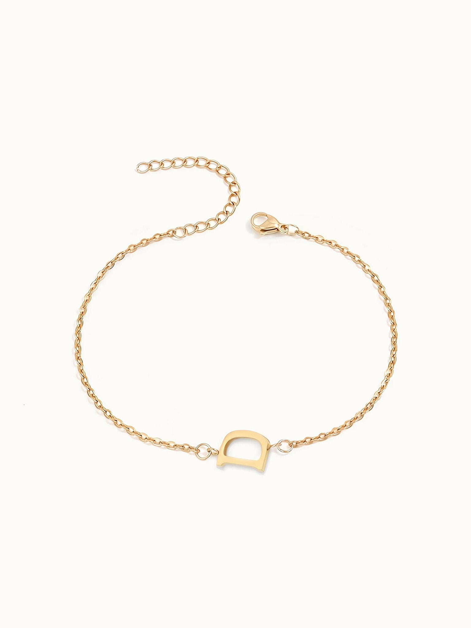 Initial Bracelet – letter D charm on a fine cable chain, gold, on ivory background