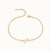 Initial Bracelet – letter E charm on a fine cable chain, gold, on ivory background