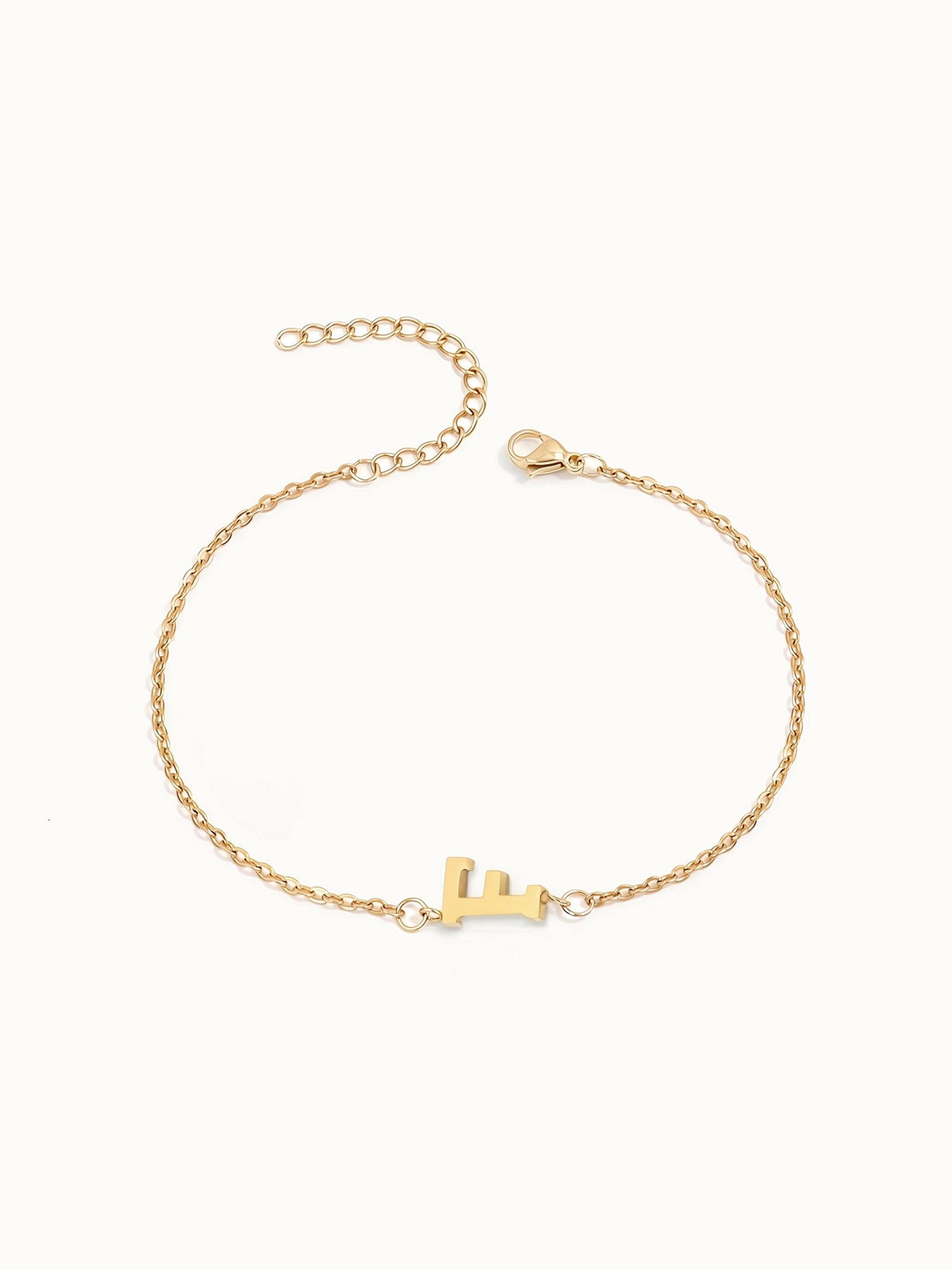 Initial Bracelet – letter F charm on a fine cable chain, gold, on ivory background