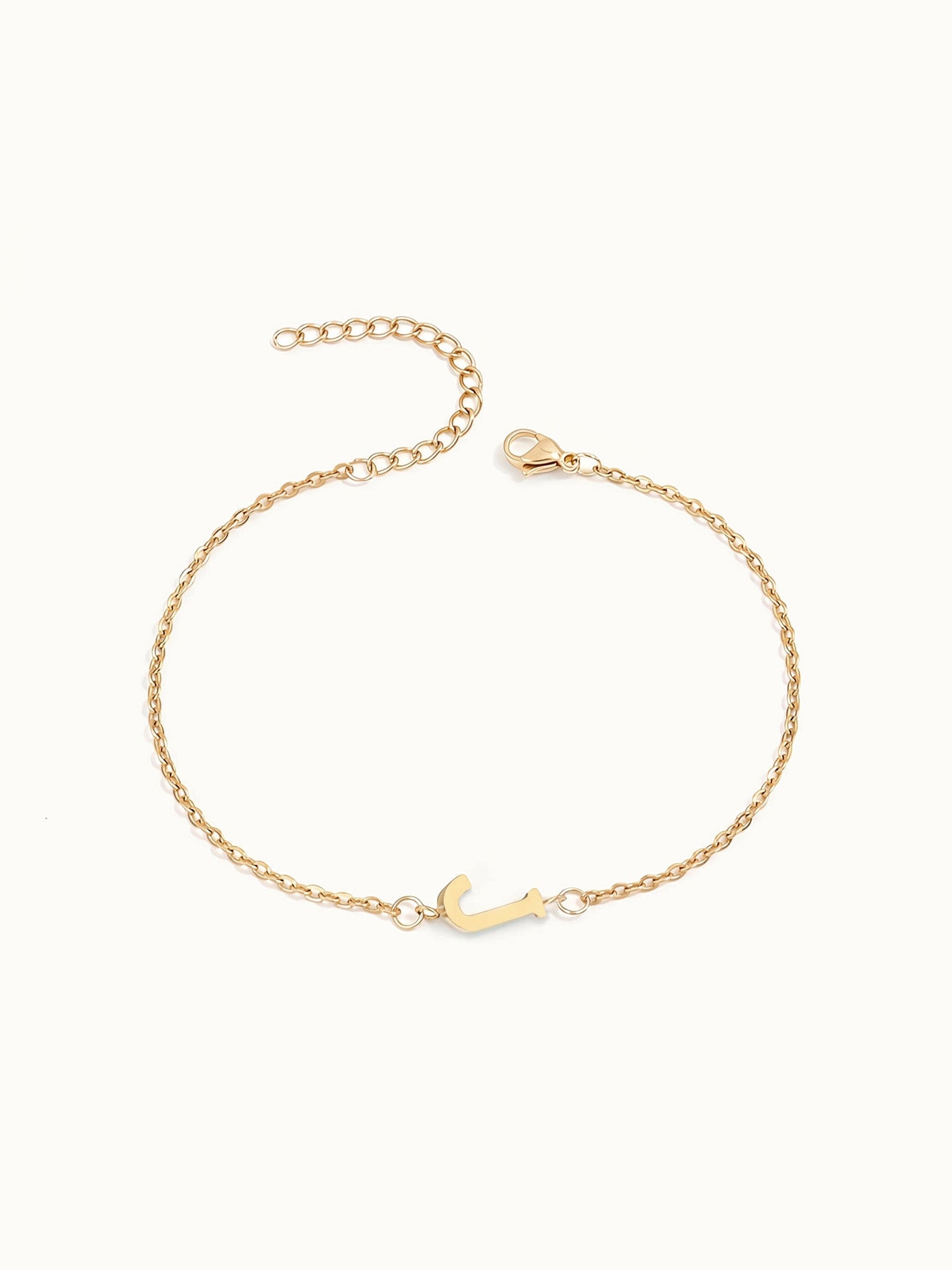 Initial Bracelet – letter J charm on a fine cable chain, gold, on ivory background