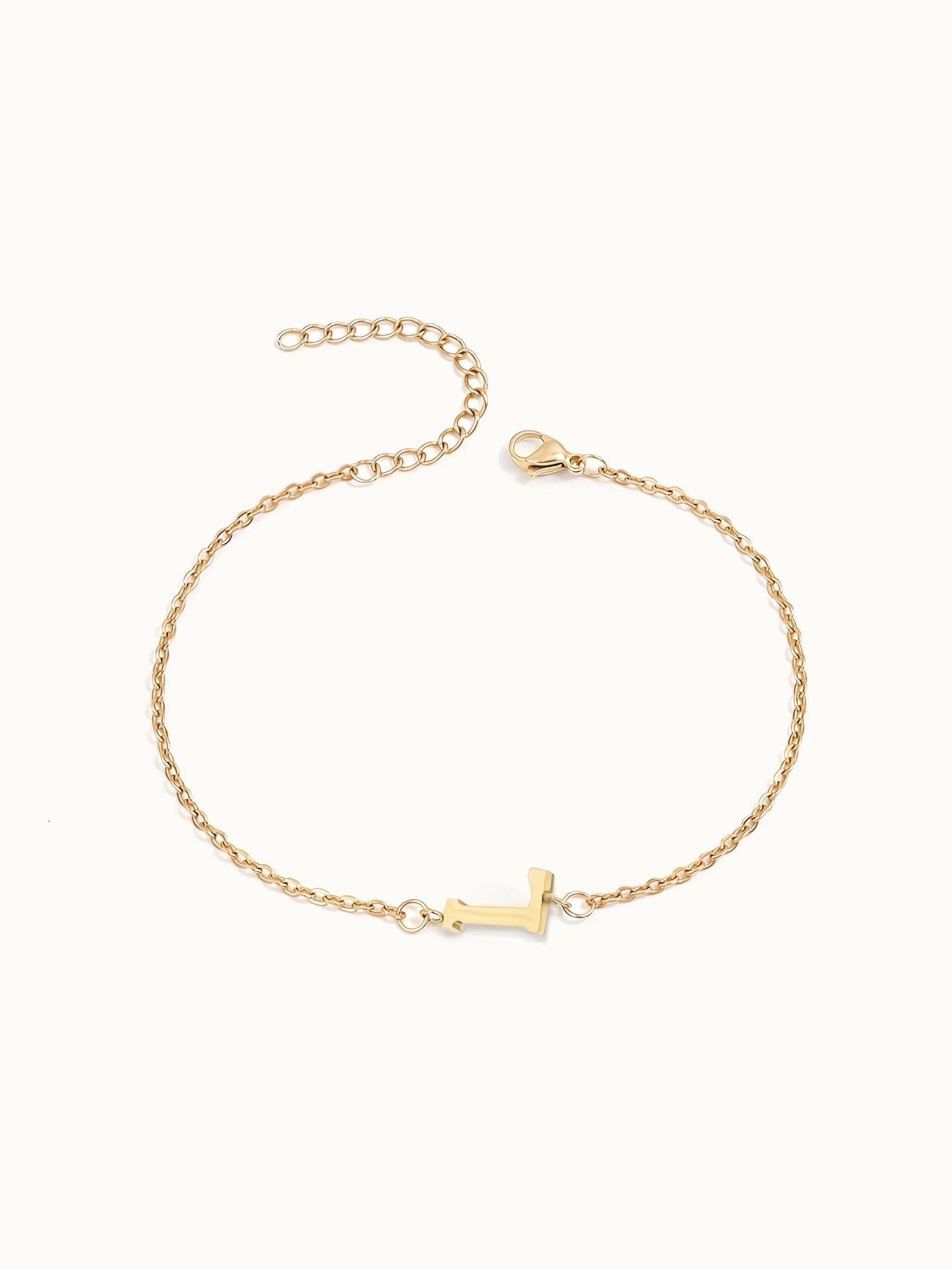 Initial Bracelet – letter L charm on a fine cable chain, gold, on ivory background