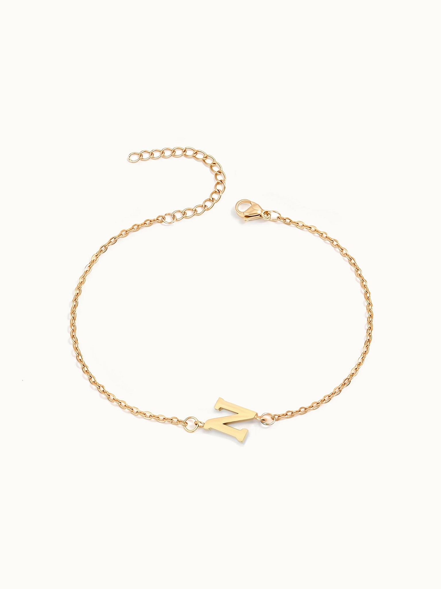 Initial Bracelet – letter N charm on a fine cable chain, gold, on ivory background