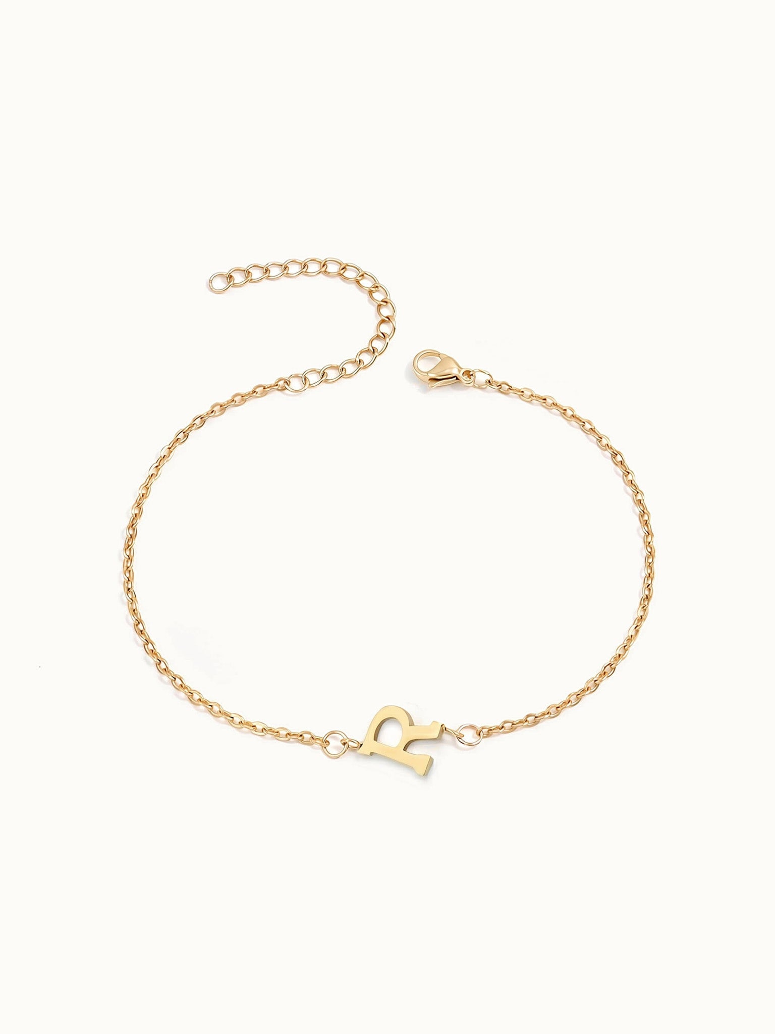 Initial Bracelet – letter R charm on a fine cable chain, gold, on ivory background