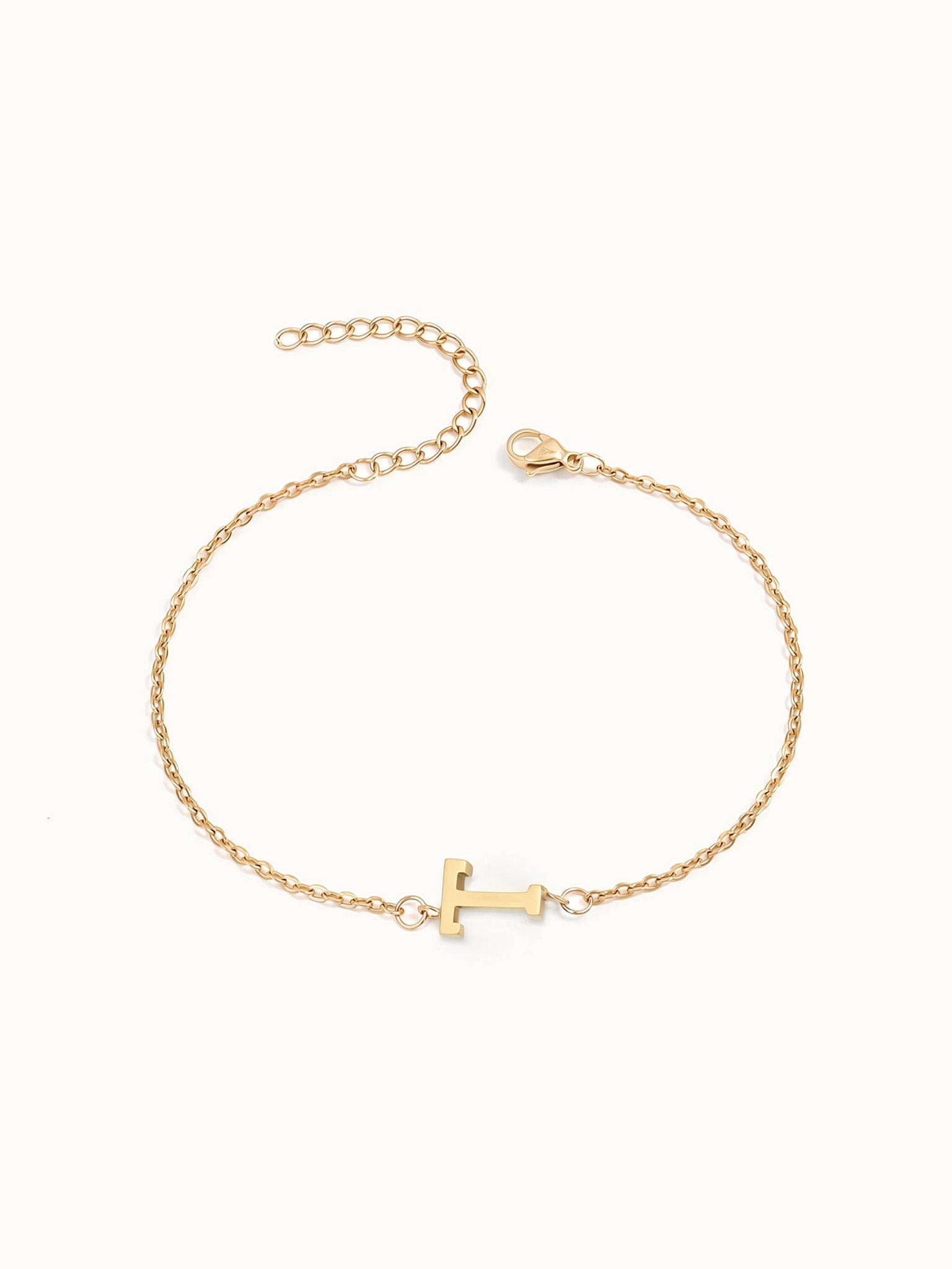 Initial Bracelet – letter T charm on a fine cable chain, gold, on ivory background
