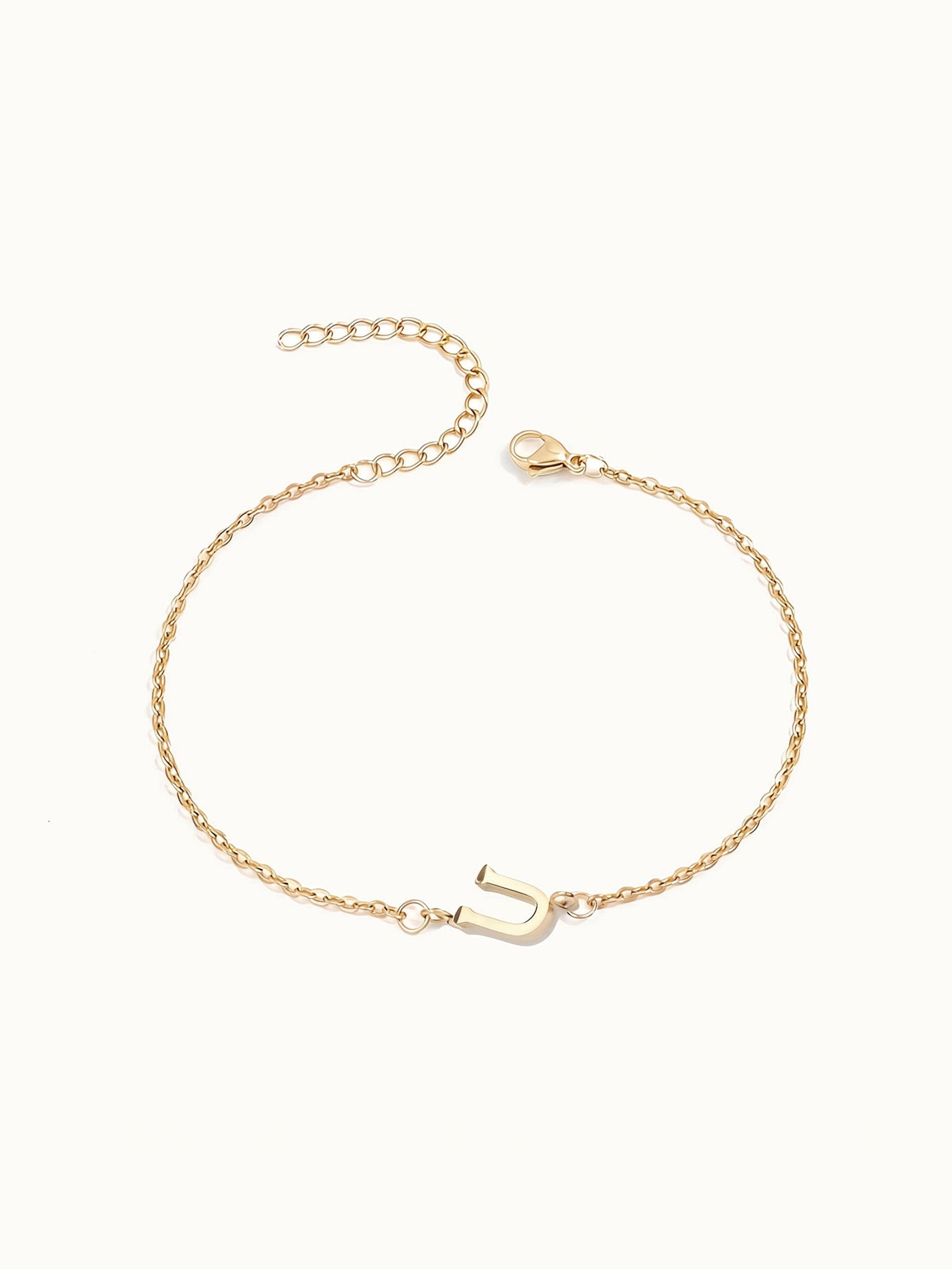 Initial Bracelet – letter U charm on a fine cable chain, gold, on ivory background