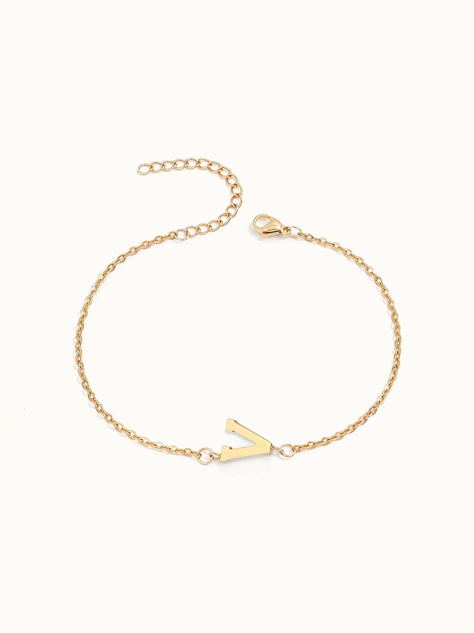 Initial Bracelet – letter V charm on a fine cable chain, gold, on ivory background