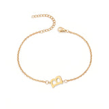 Initial Bracelet in gold with letter B charm, flat lay on white background