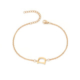 Initial Bracelet in gold with letter D charm, flat lay on white background