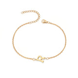 Initial Bracelet in gold with letter R charm, flat lay on white background