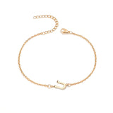 Initial Bracelet in gold with letter U charm, flat lay on white background