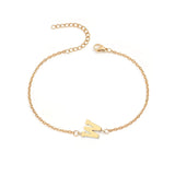 Initial Bracelet in gold with letter W charm, flat lay on white background